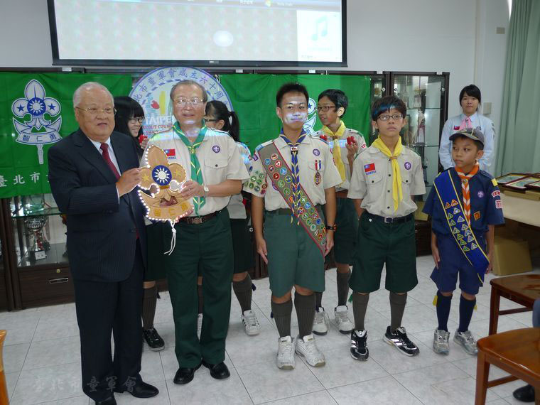 薪火相傳，由總會指導委員、前市長許水德先生將童軍精神傳遞給康理事長(本會檔案)